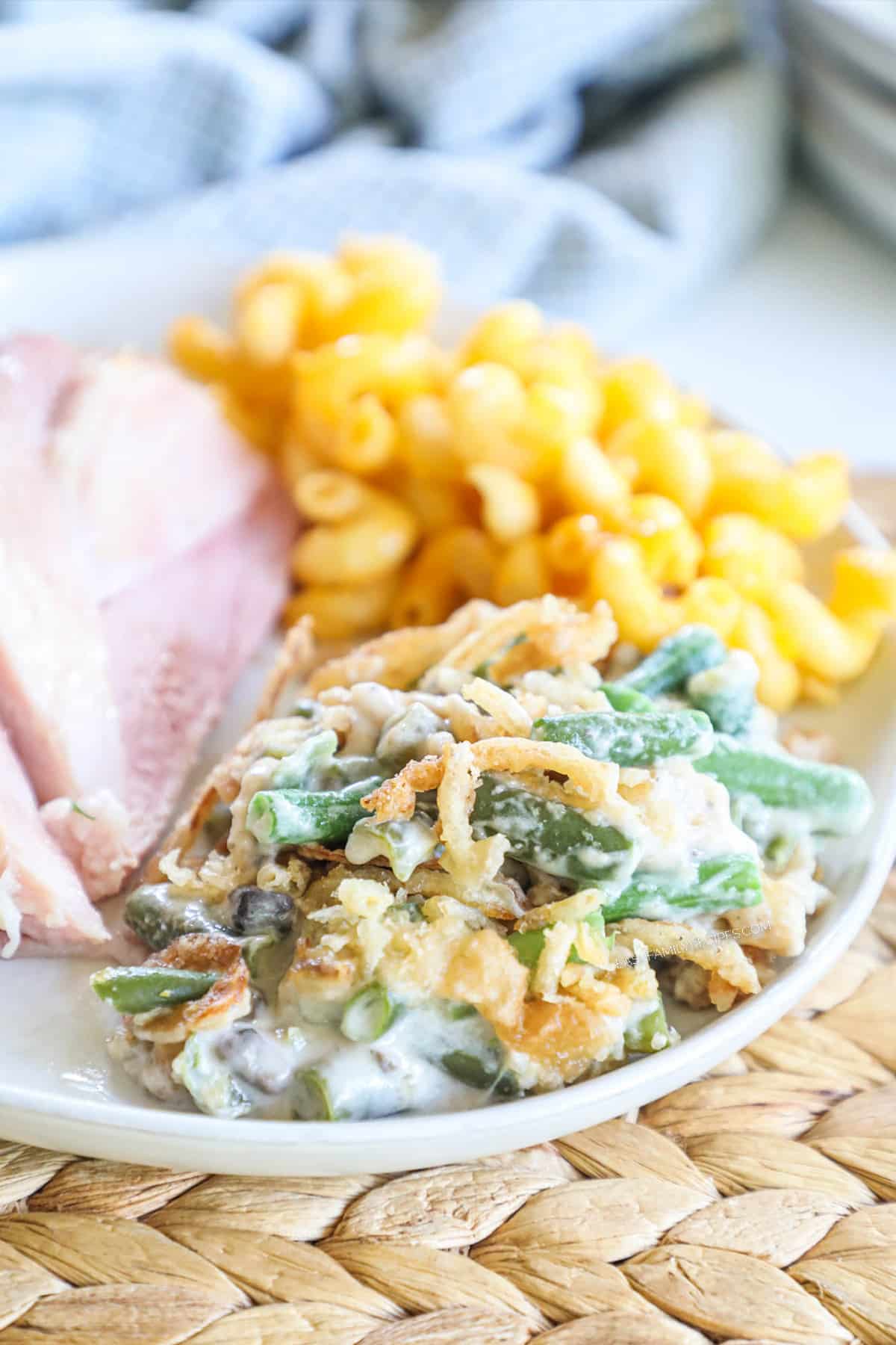 A plate of classic holiday food - macaronie and cheese, ham and green bean casserole