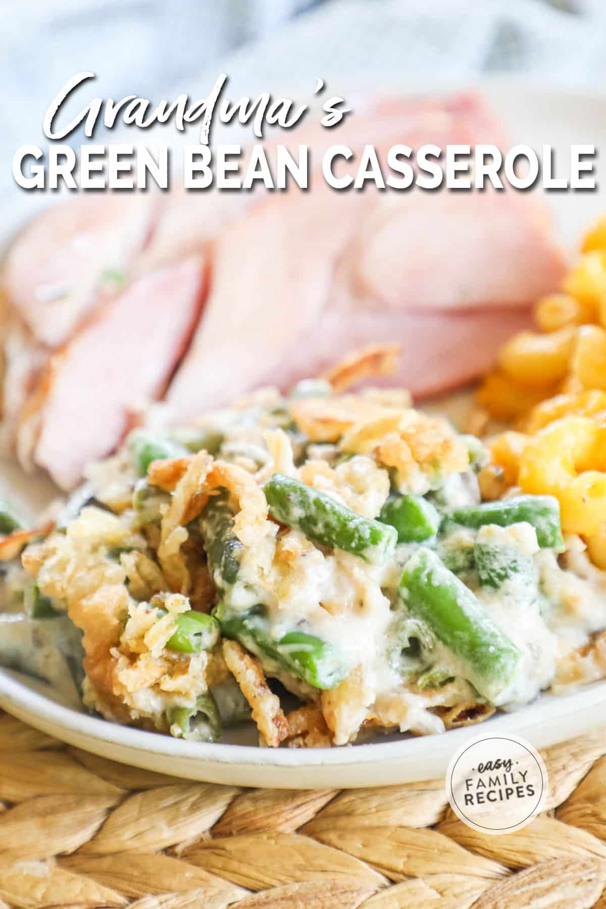 a plate with green bean casserole served with mac and cheese and ham.