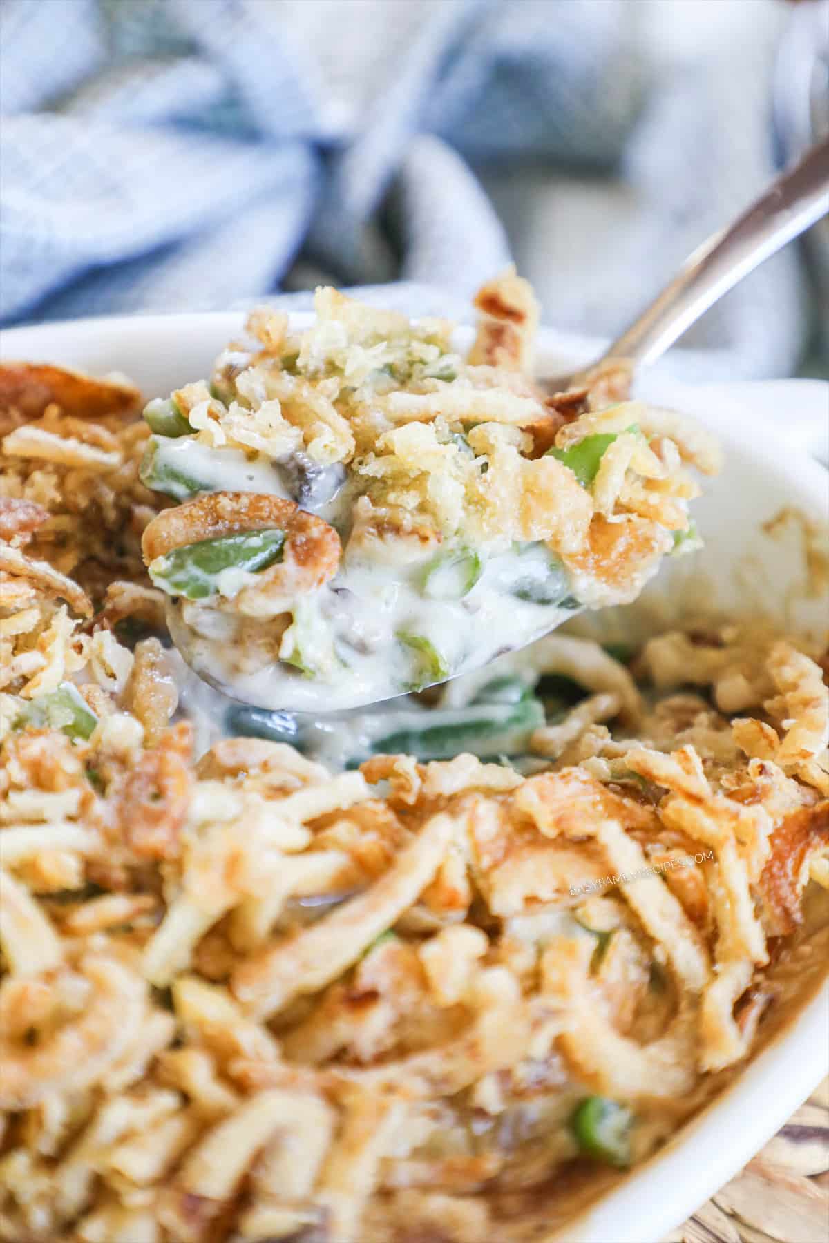 Green Bean Casserole being scooped out of a white baking dish