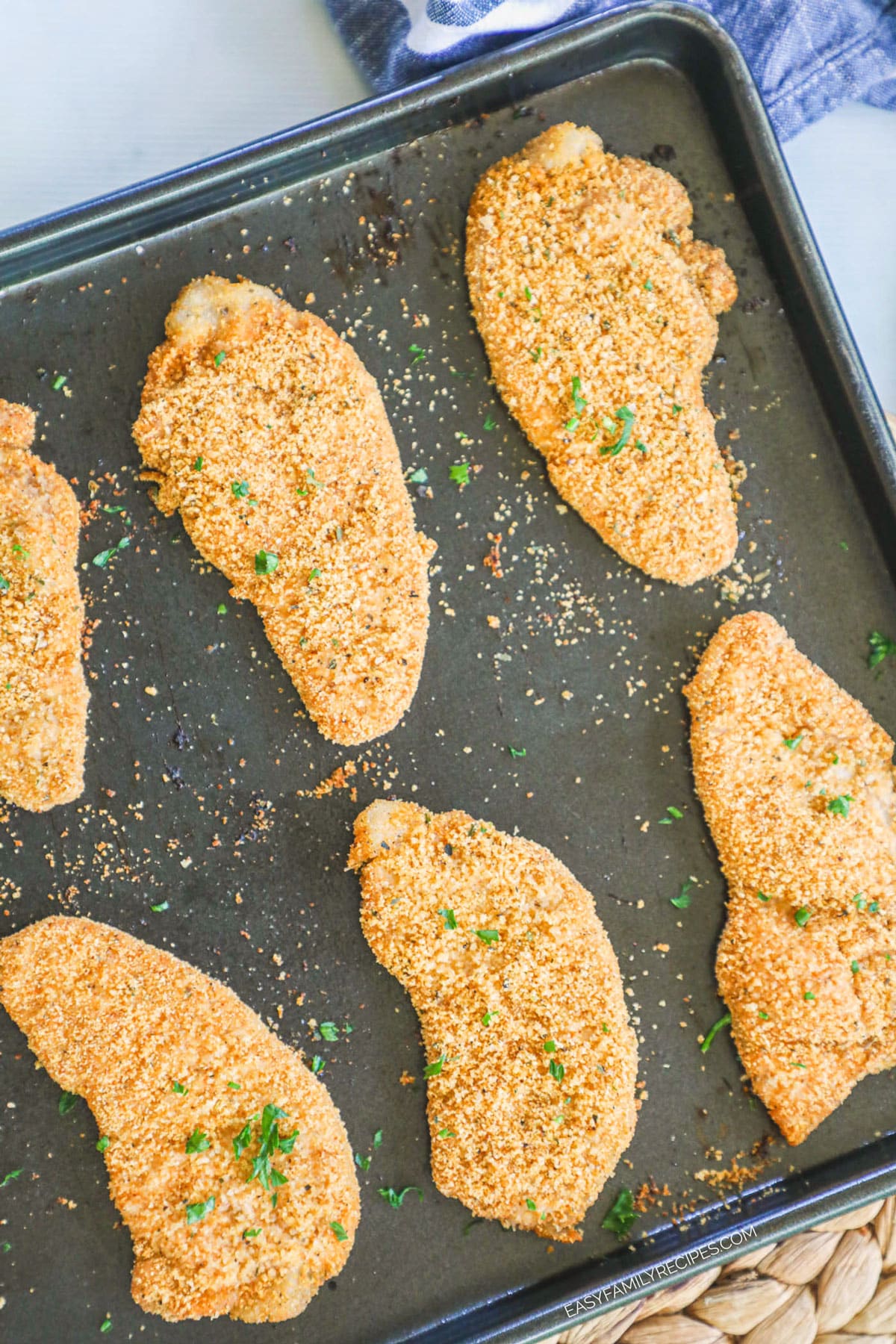 Pork Chops covered in shake and bake on a cookie sheet.