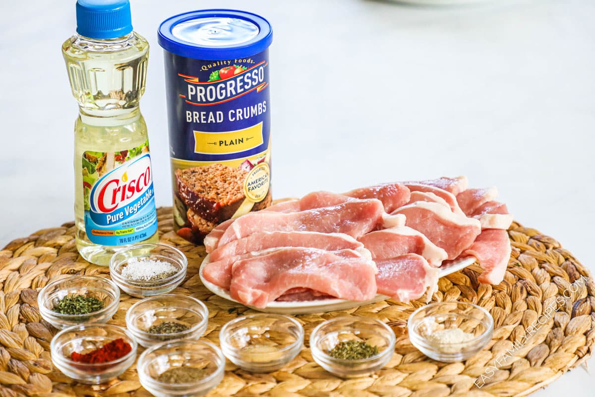 ingredients to make shake and bake pork chops including oil, breadcrumbs, seasoning, and cutlets.