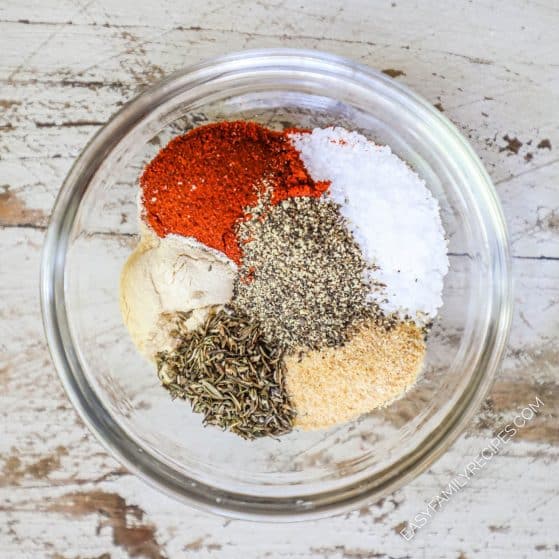 Ingredients for rotisserie chicken seasoning in a glass bowl