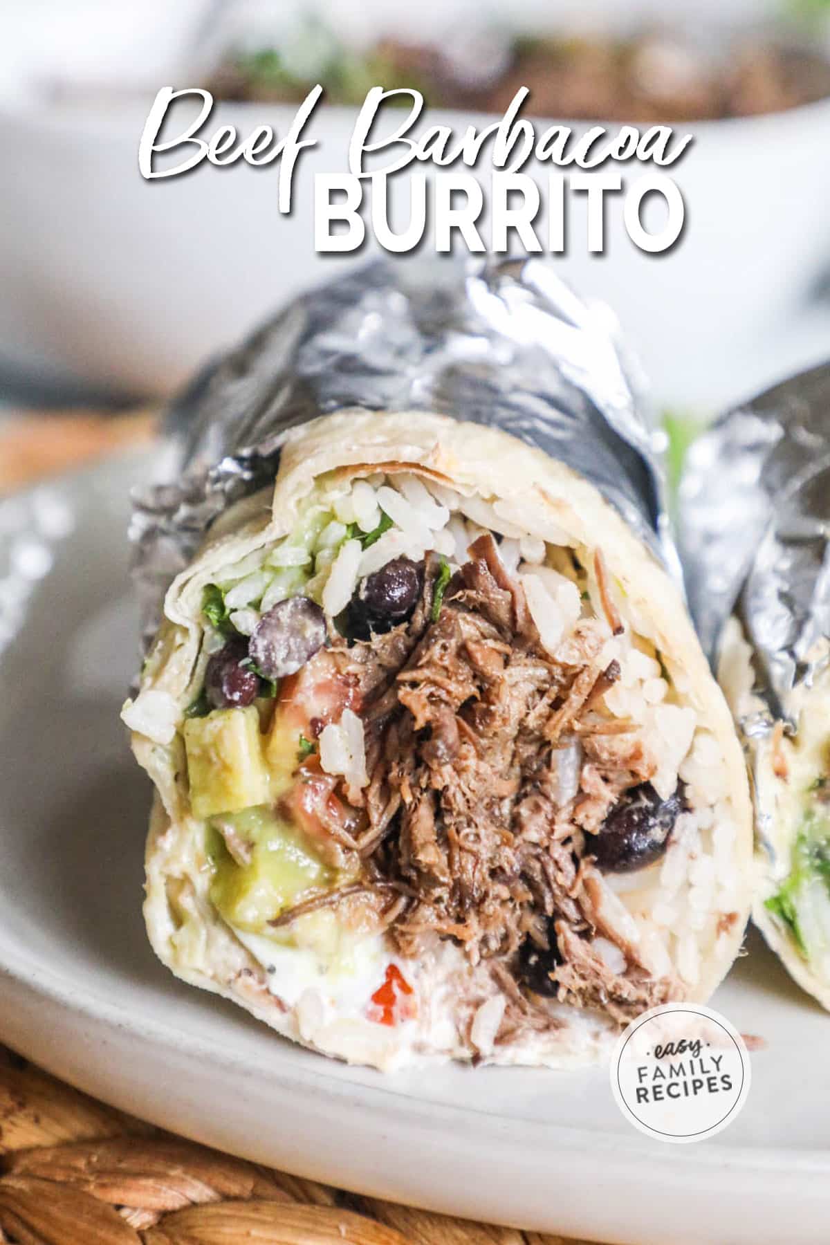 A completed burrito cut open to show all the fillings and wrapped in foil.