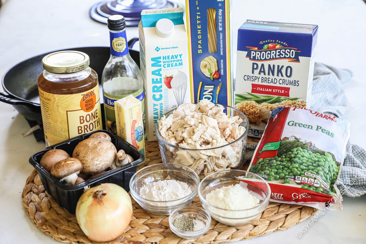Ingredients to make chicken tetrazzini including chicken, breadcrumbs, peas, pasta, mushrooms, cream, and onion.
