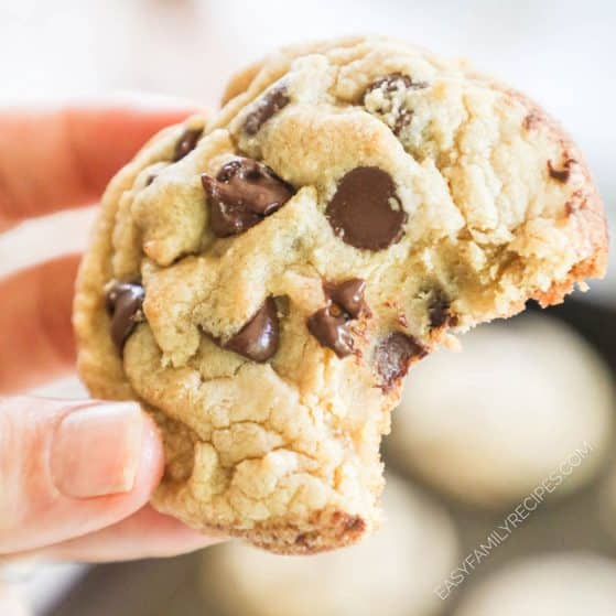 Close up of cookie with chocolate chips with a bite taken out to show texture.