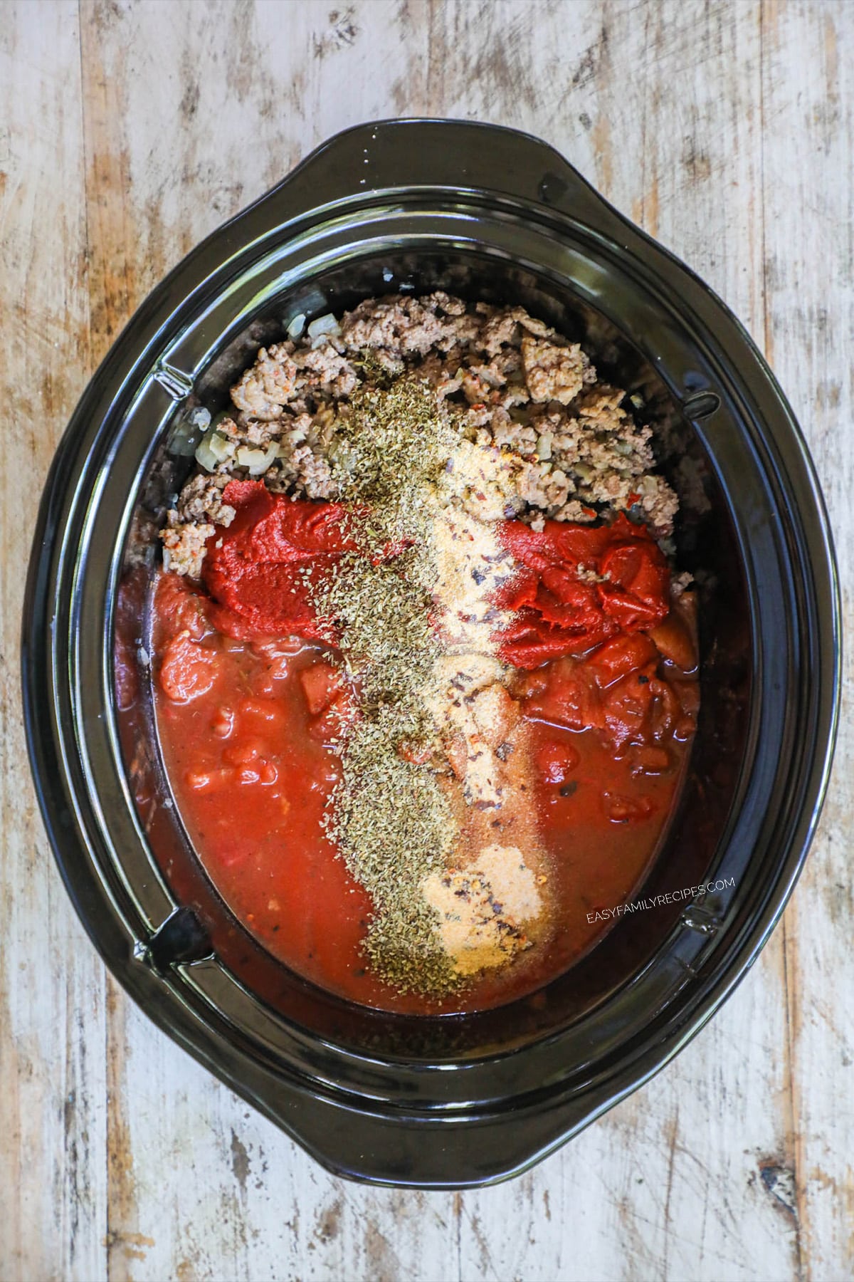 Step 2 - ground beef and seasonings in crockpot before being mixed.