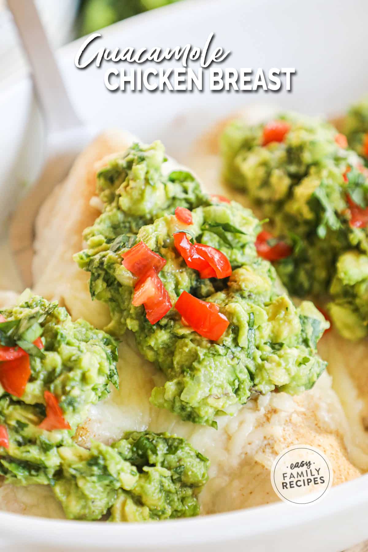 A spatula removing a chicken breast with guacamole on top from the pan.