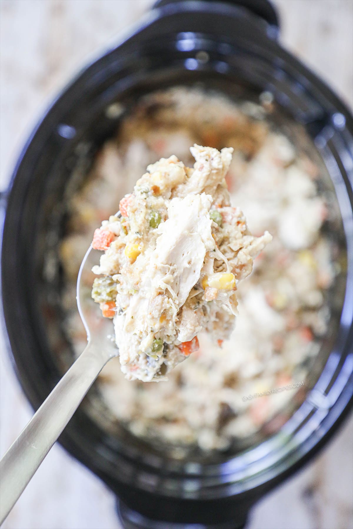 Chicken and stuffing being spooned out of a slow cooker after it has cooked for 3-4 hours.