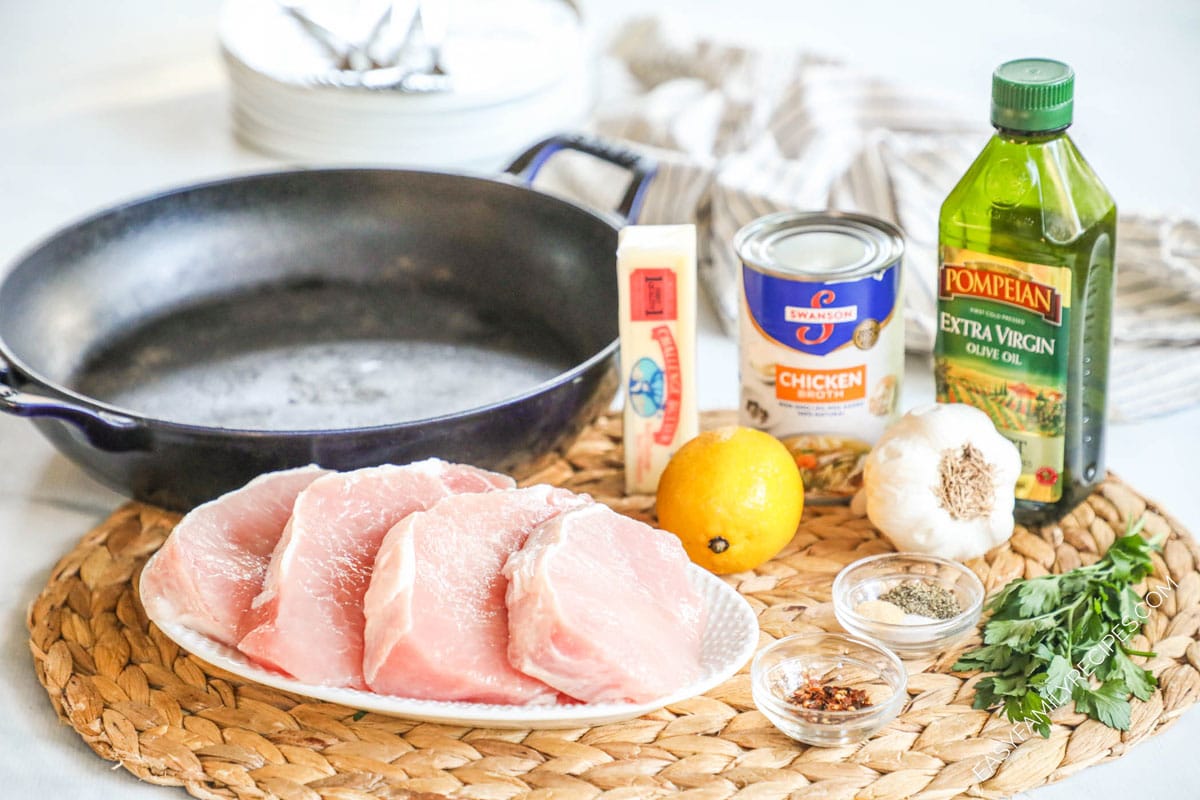 ingredients to make garlic butter pork bites including pork chops, lemon, garlic, oil, broth, and butter.