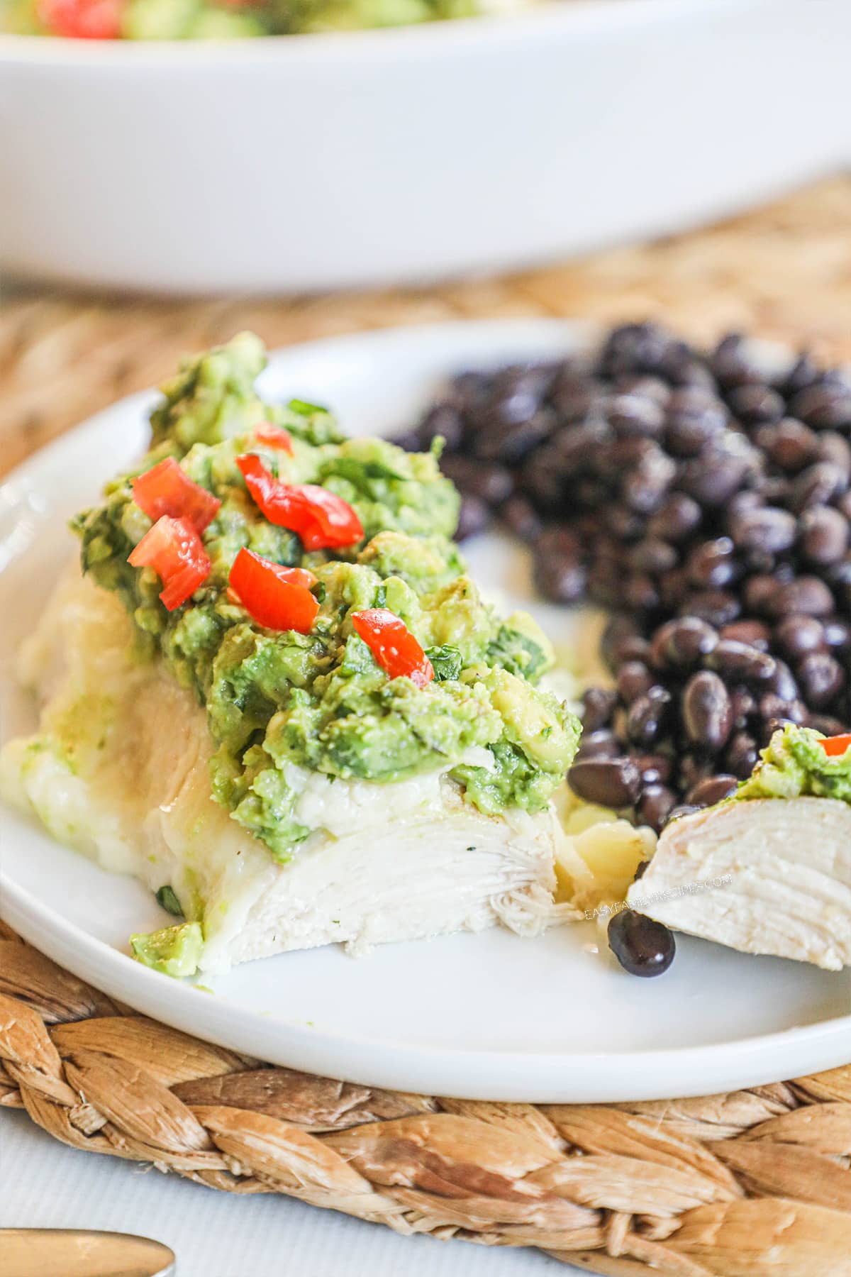 Guacamole chicken served on a plate with black beans