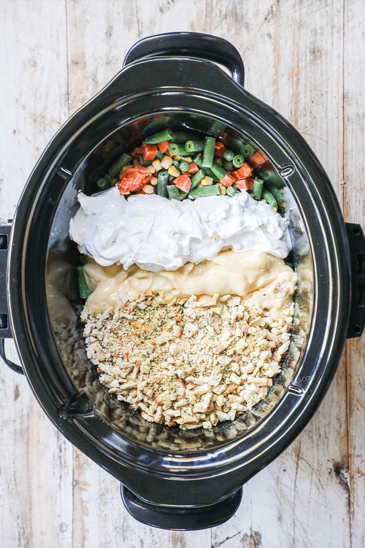 Chicken and stuffing ingredients in a slow cooker before being cooked.