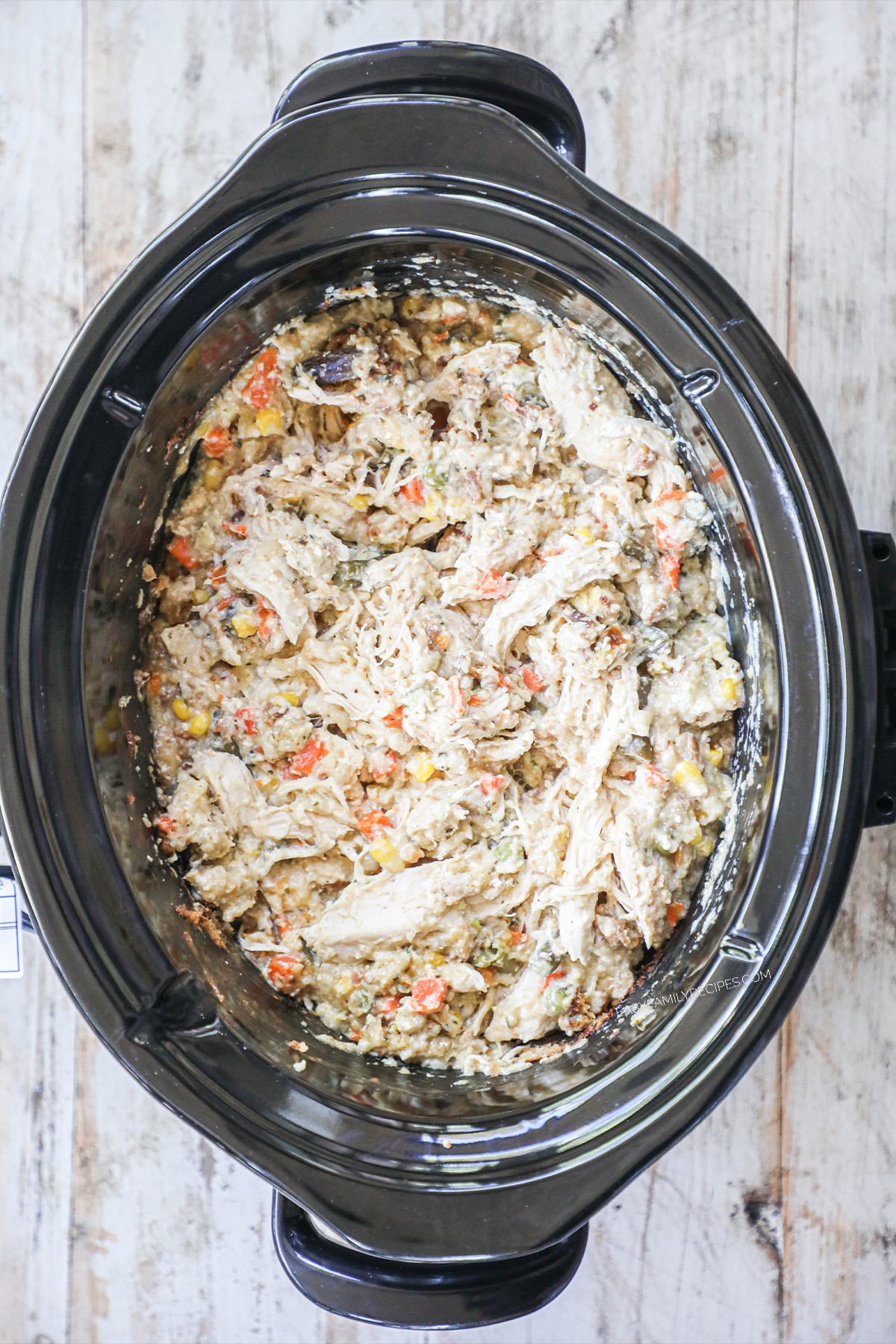 Chicken and stuffing in a slow cooker after it has cooked for 3-4 hours.