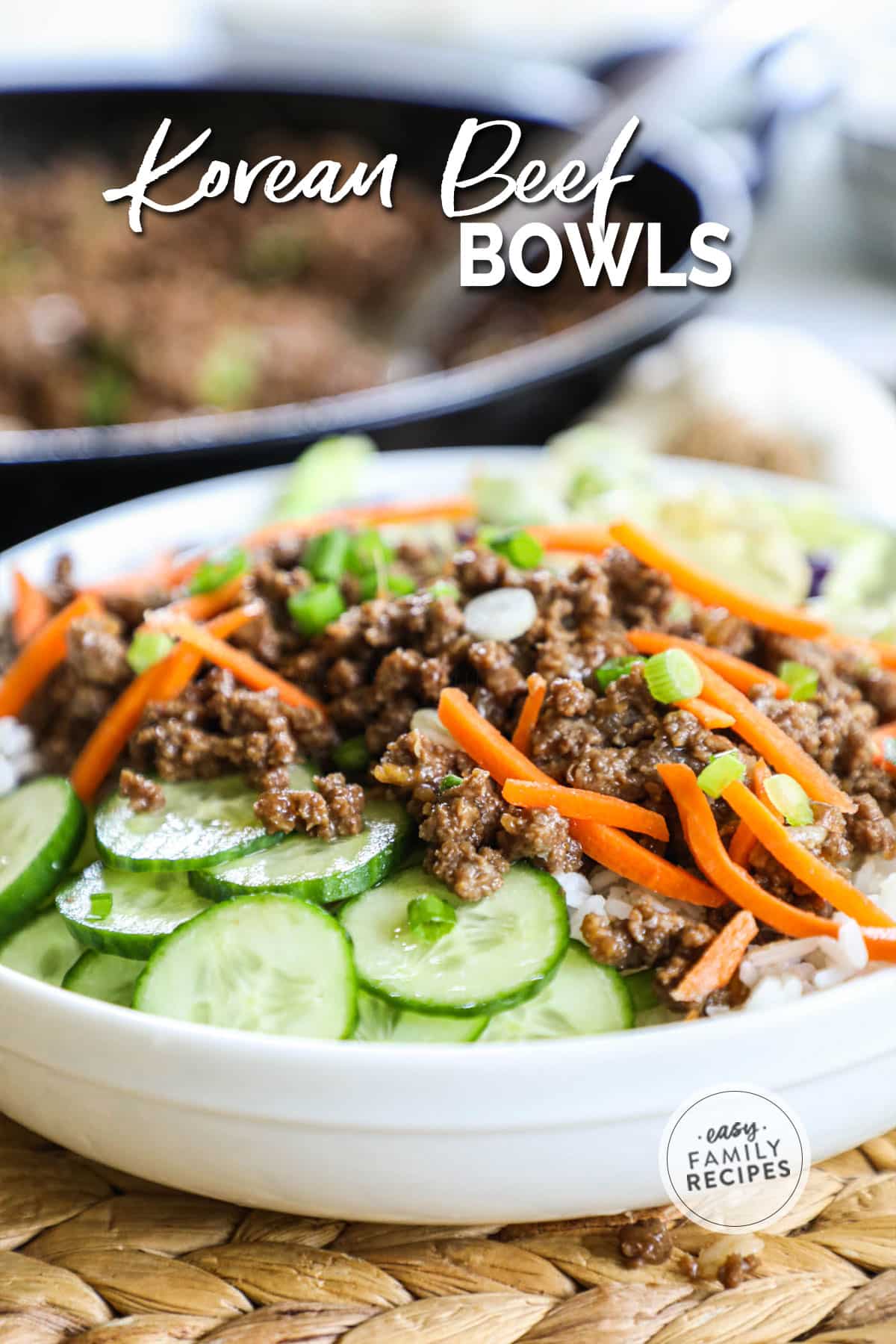 Completed korean beef bowl with rice, cucumbers, beef, and carrots.