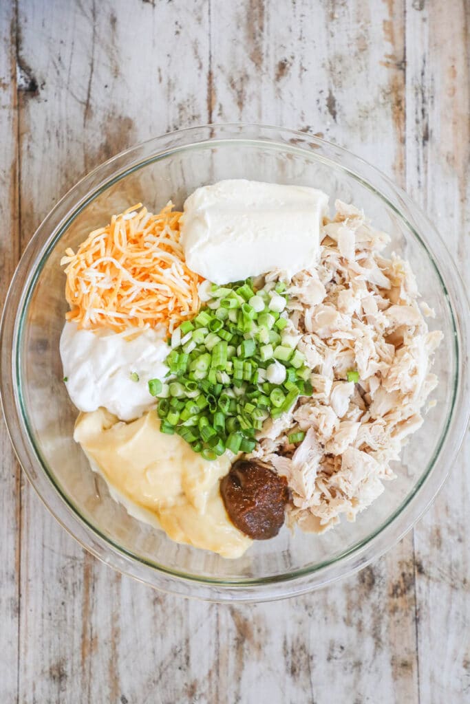 Steps to make Million Dollar Chicken Casserole Step 1:Combine the shredded chicken, cream cheese, sour cream, cream of chicken soup, chicken base and green onions in a large bowl