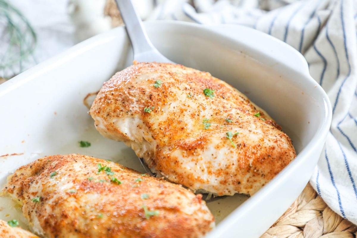 Serving baked chicken breast by lifting from baking dish with a spatula