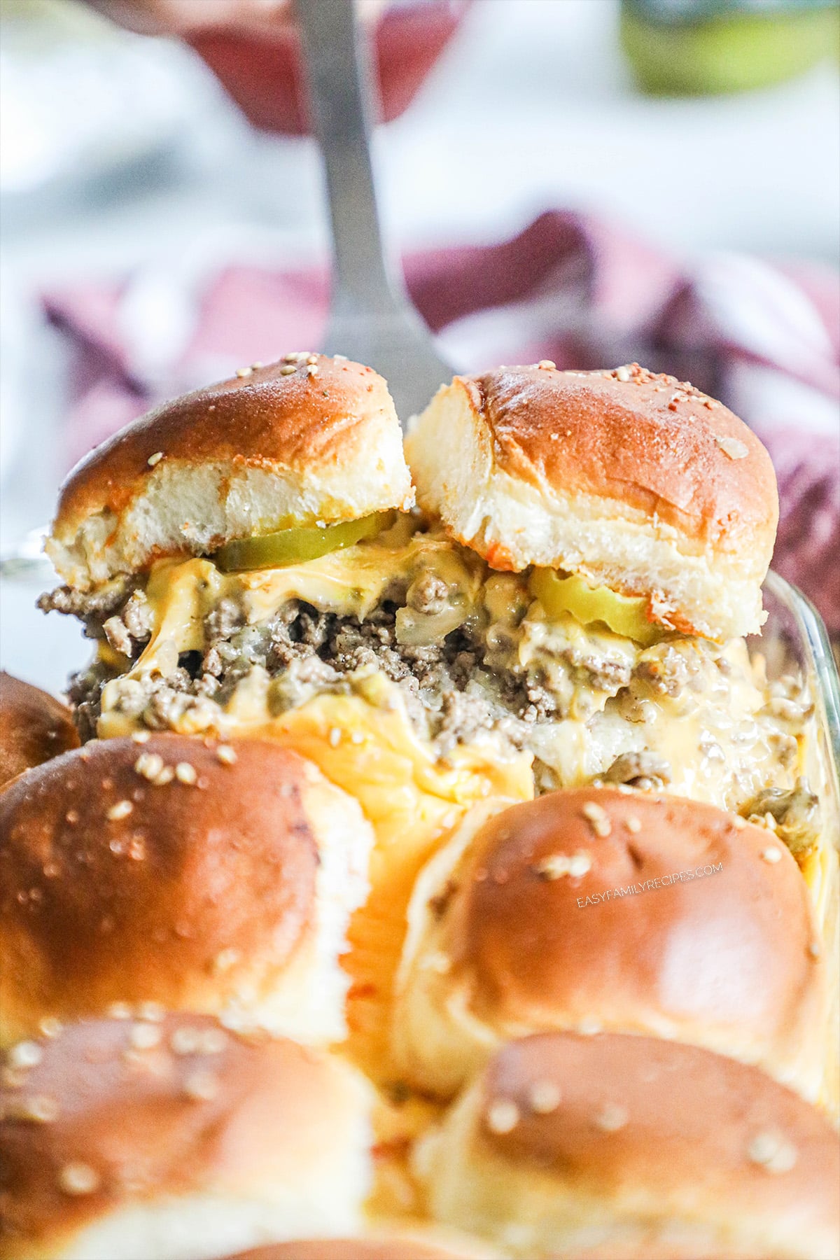 Lifting two Cheeseburger Sliders on Hawaiian rolls out of the pan.