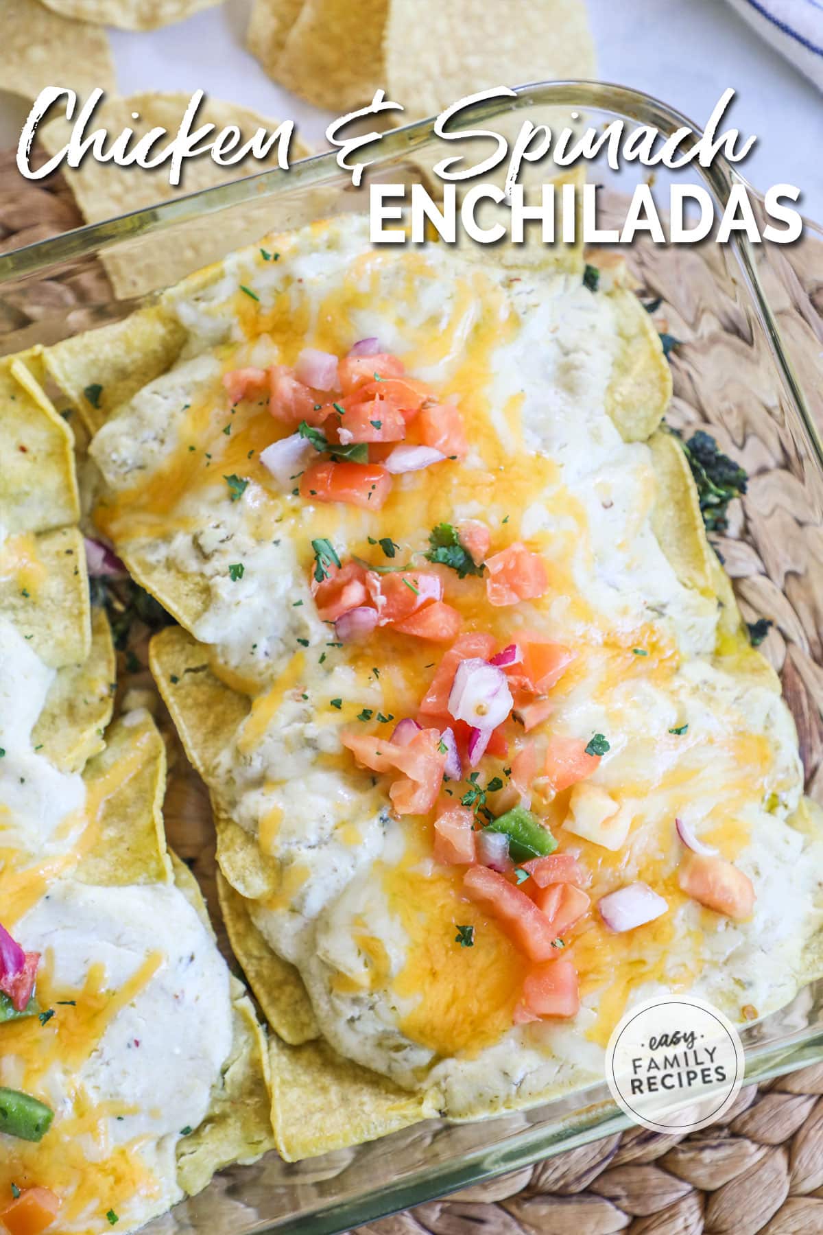 Enchiladas in a pan with golden brown cheese and topped with pico de gallo.