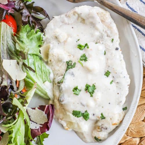 Smothered cream of mushroom pork chop on a plate.