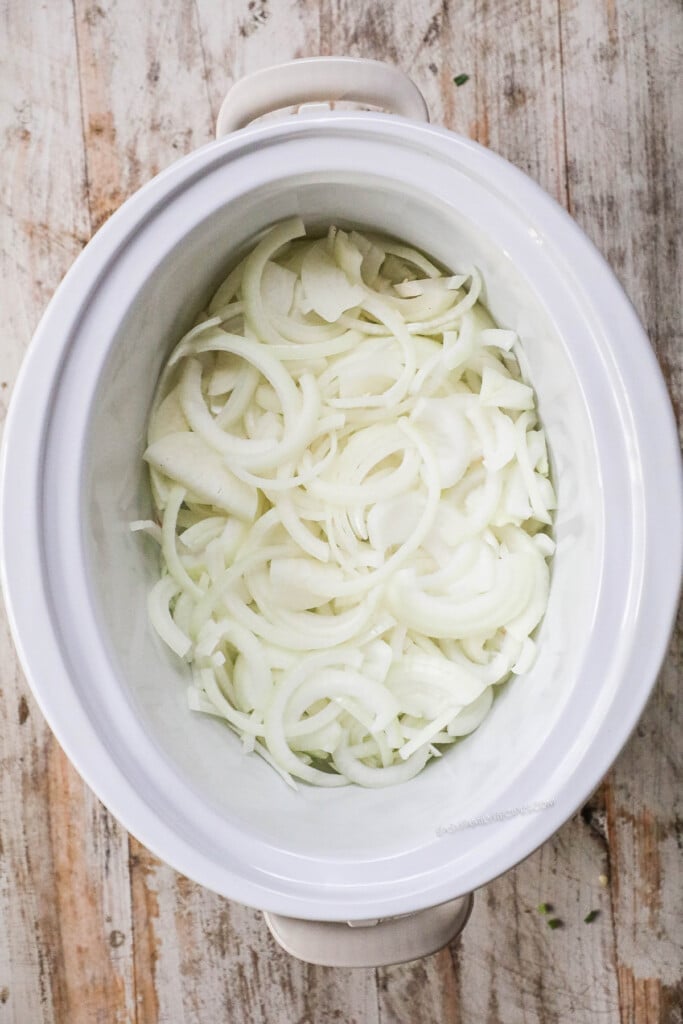 How to make French Onion Pot Roast step 1: Slice onions and place in slow cooker.