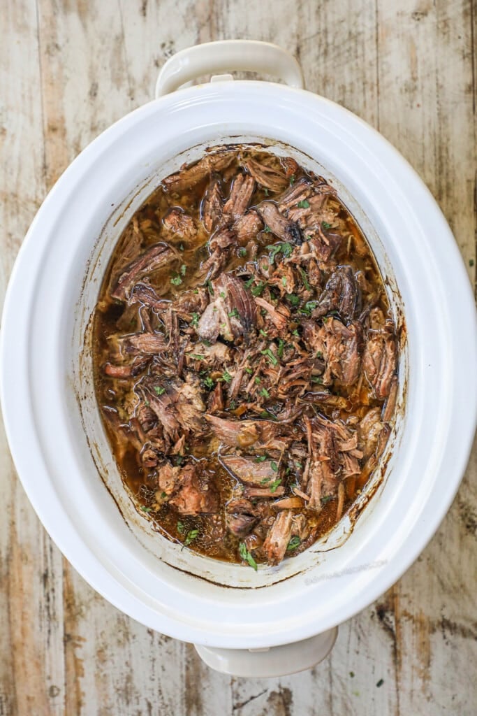 How to make French Onion Pot Roast step 5: Shred the pot roast and mix into the juices.