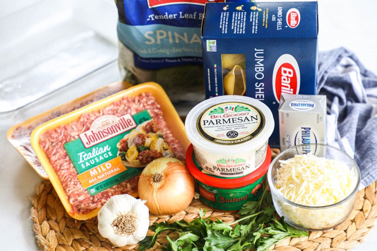 ingredients for spinach and sausage stuffed shells - pasta shells, marinara, sausage, garlic, onion, cheeses, cream cheese, parsley and spinach