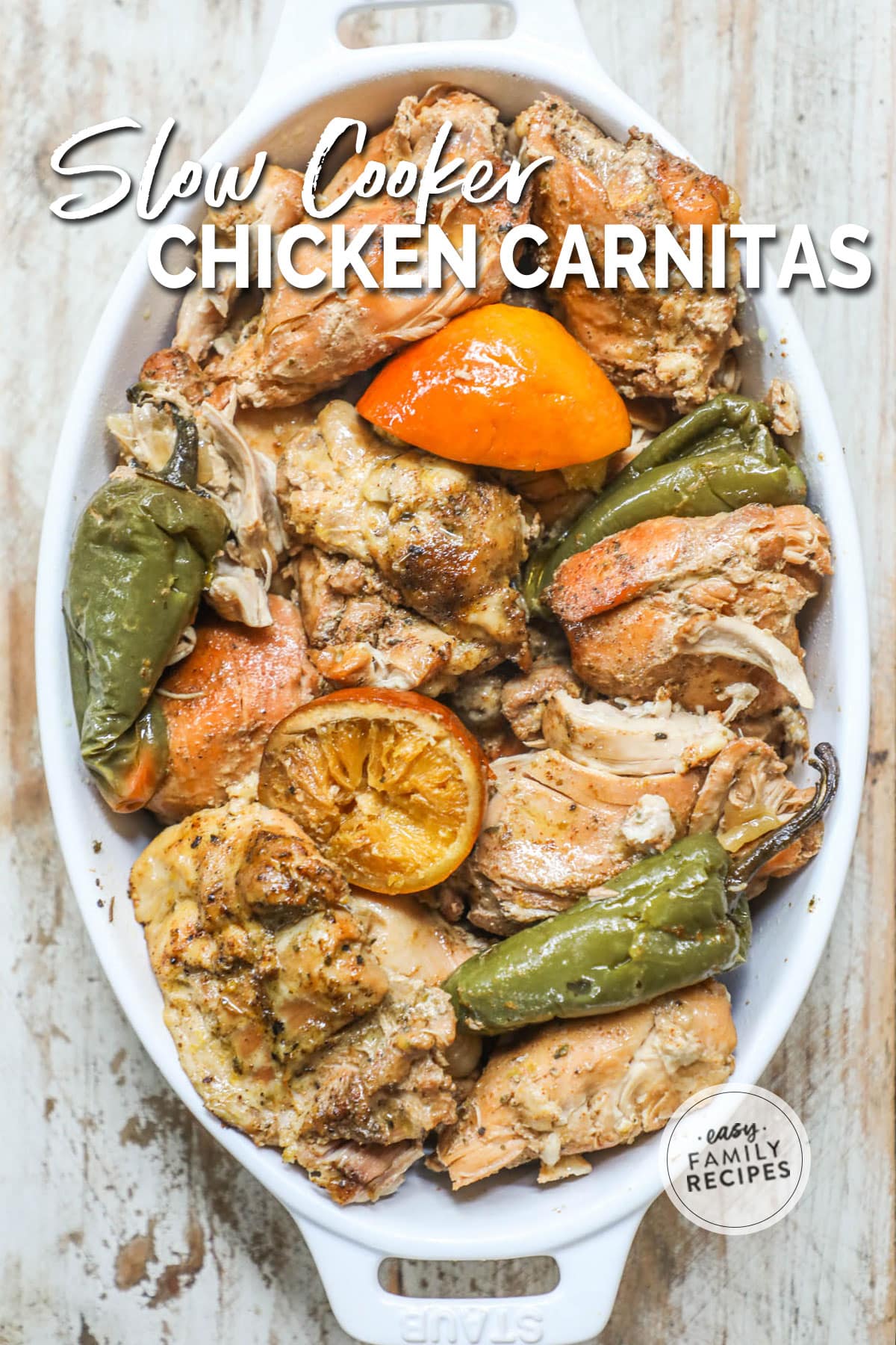 a serving dish filled with chicken carnitas, oranges, and jalapeños