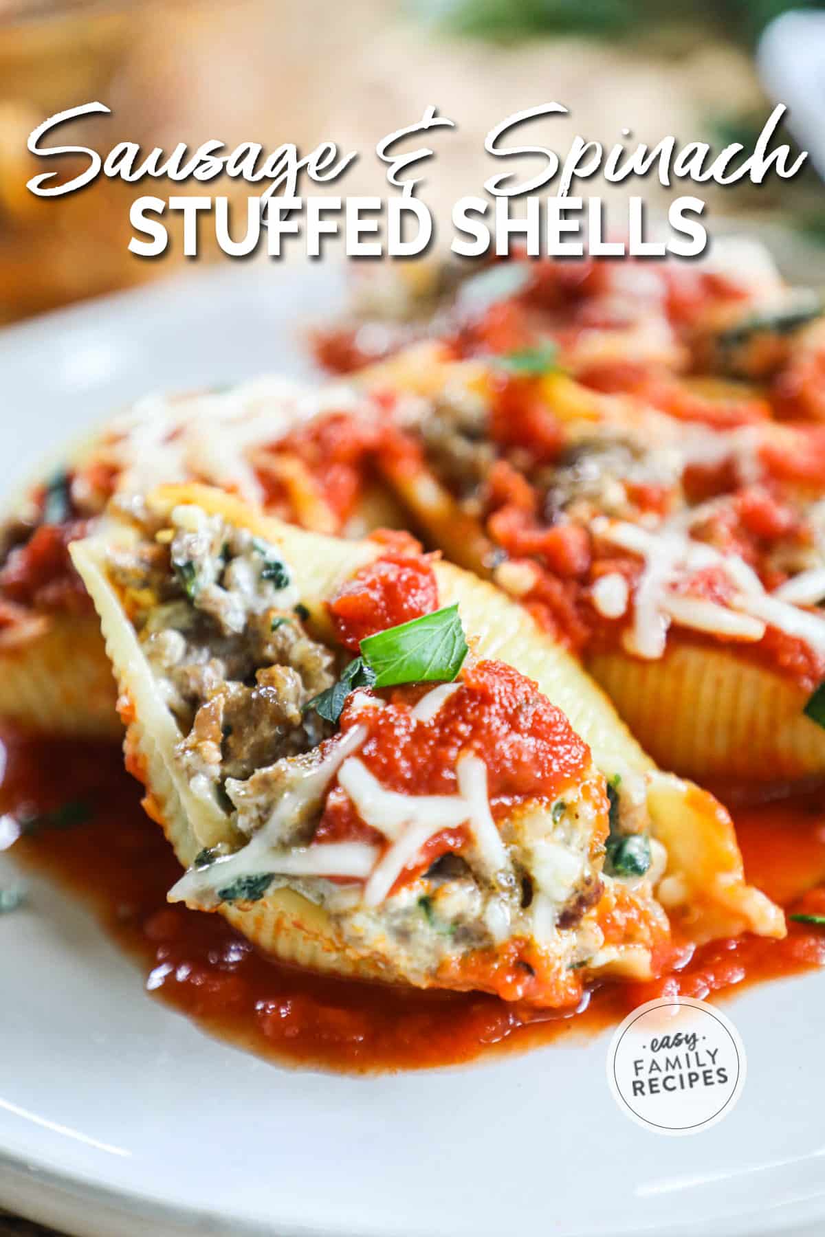 large pasta shells with a sausage spinach filling on a plate.