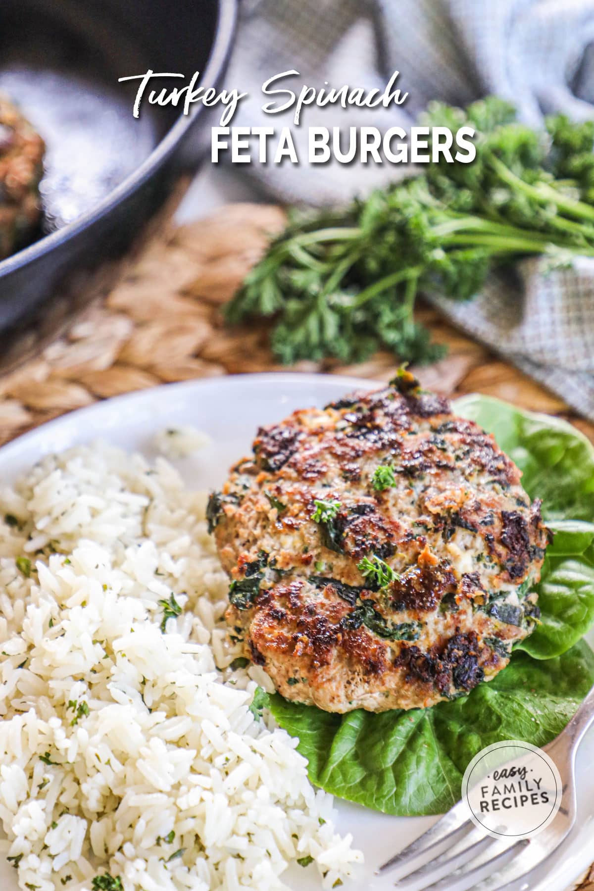 a spinach turkey burger on a plate with lettuce and white rice.