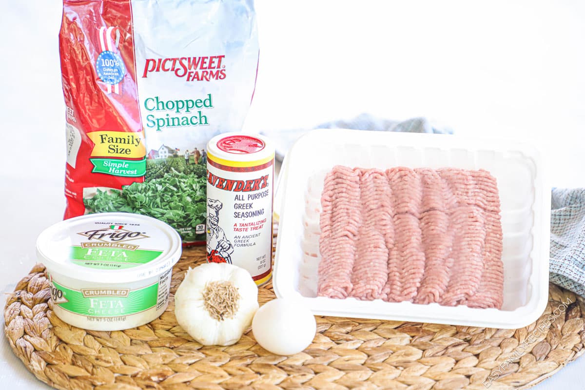 ingredients to make turkey spinach feta burgers including Greek seasoning, oil, feta cheese, and frozen spinach.