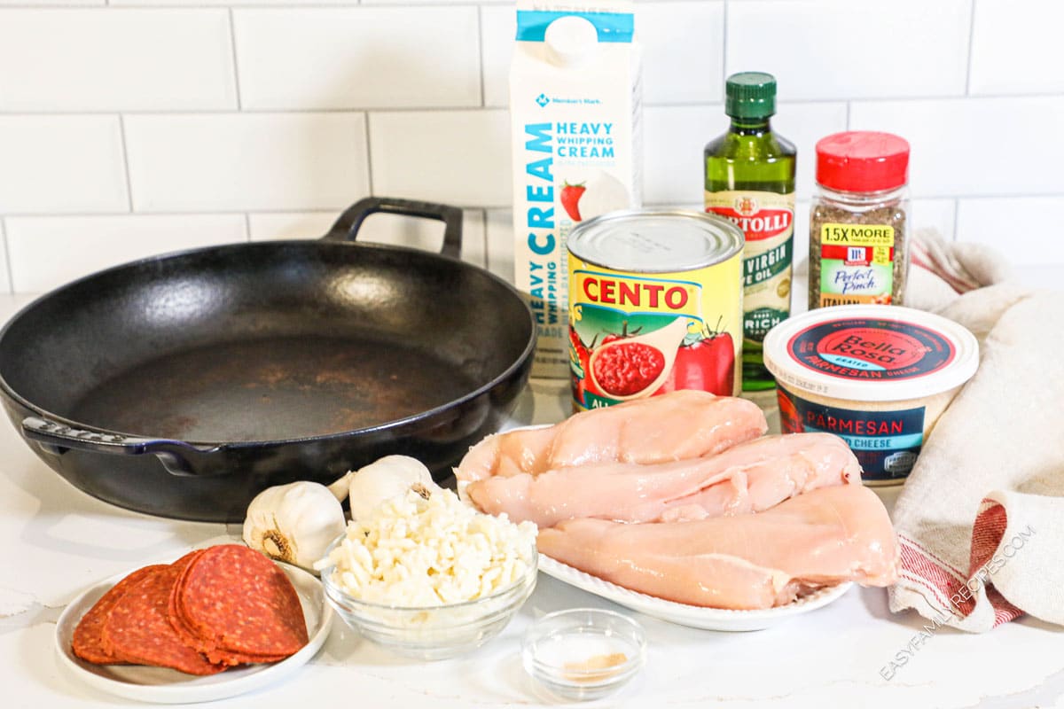 Ingredients for chicken pizzaiola, including chicken breasts, pepperoni, mozzarella, parmesan, garlic, crushed tomatoes, and more