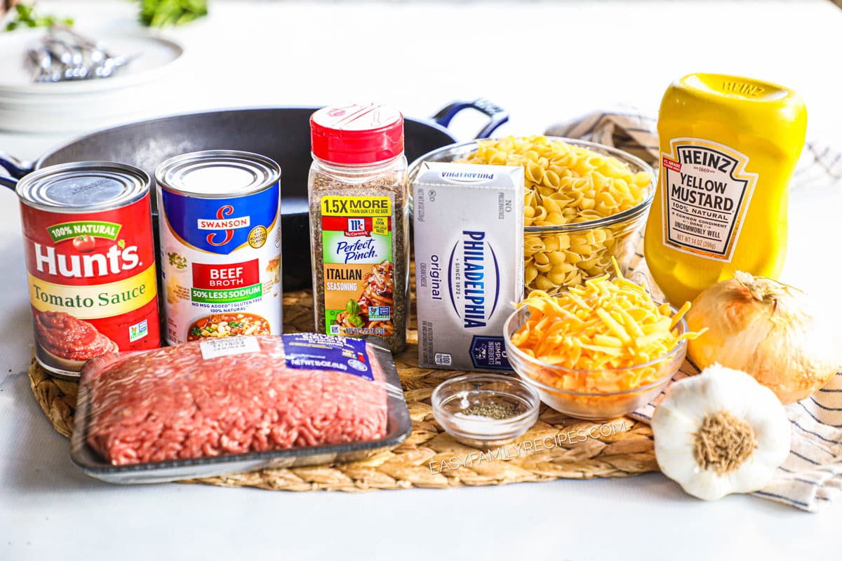 Ingredients for beef and shells including pasta, beef, cream cheese, italian seasoning, cheddar cheese, mustard, ketchup, and salt and pepper.