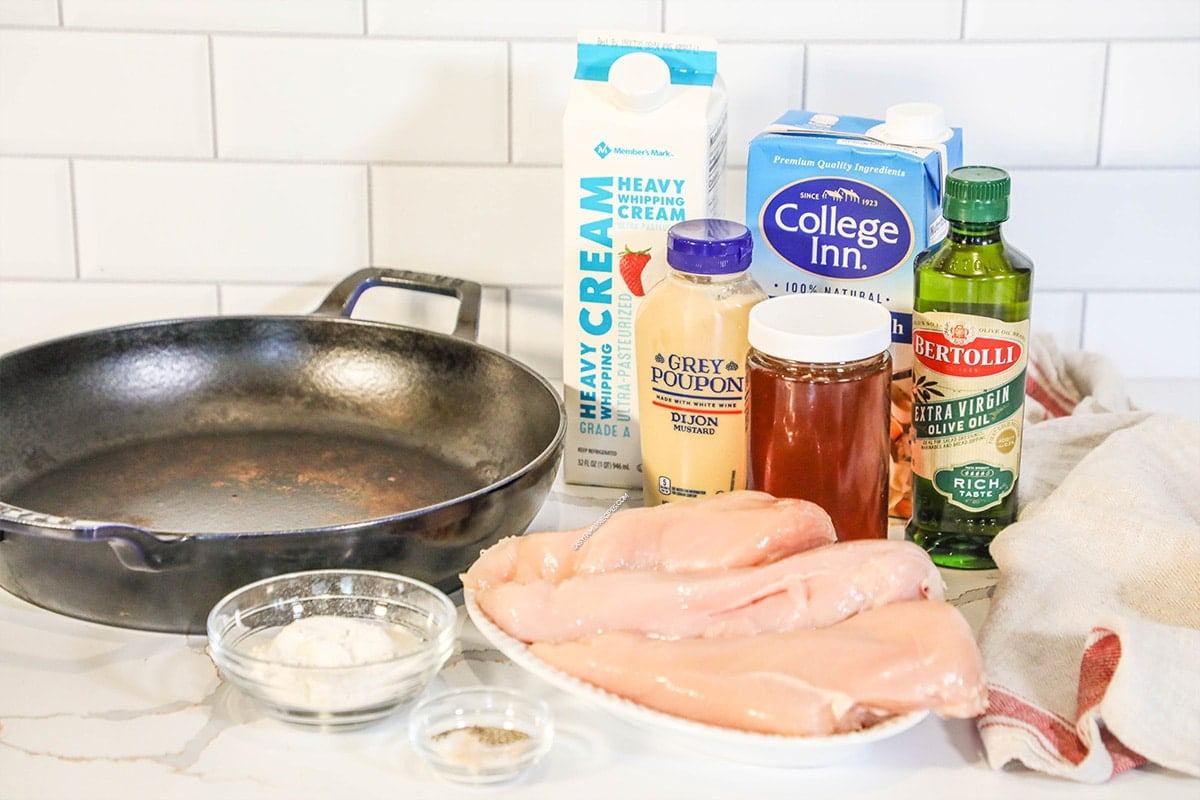 Ingredients for making dijon chicken including chicken breast, dijon mustard, honey, chicken broth, and heavy cream.