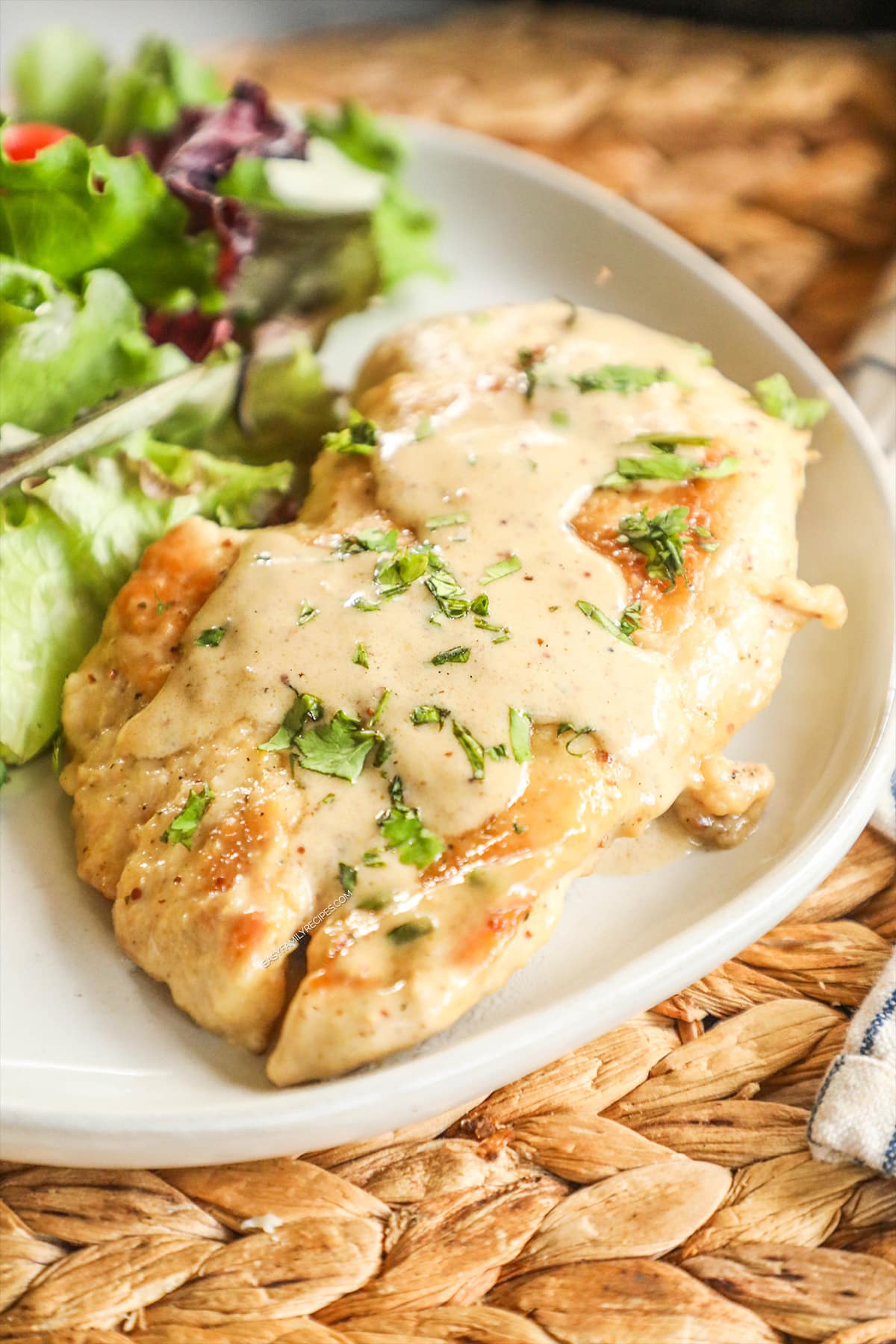 Creamy Dijon Chicken served on a plate with salad.