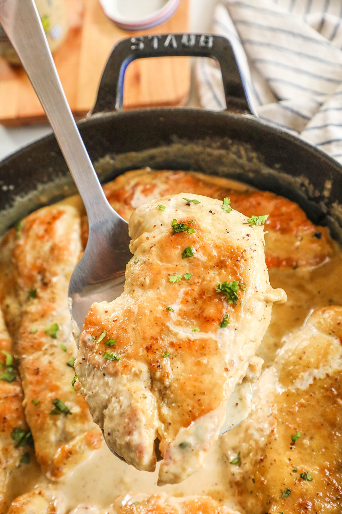 Lifting Honey Dijon Chicken out of the pan.