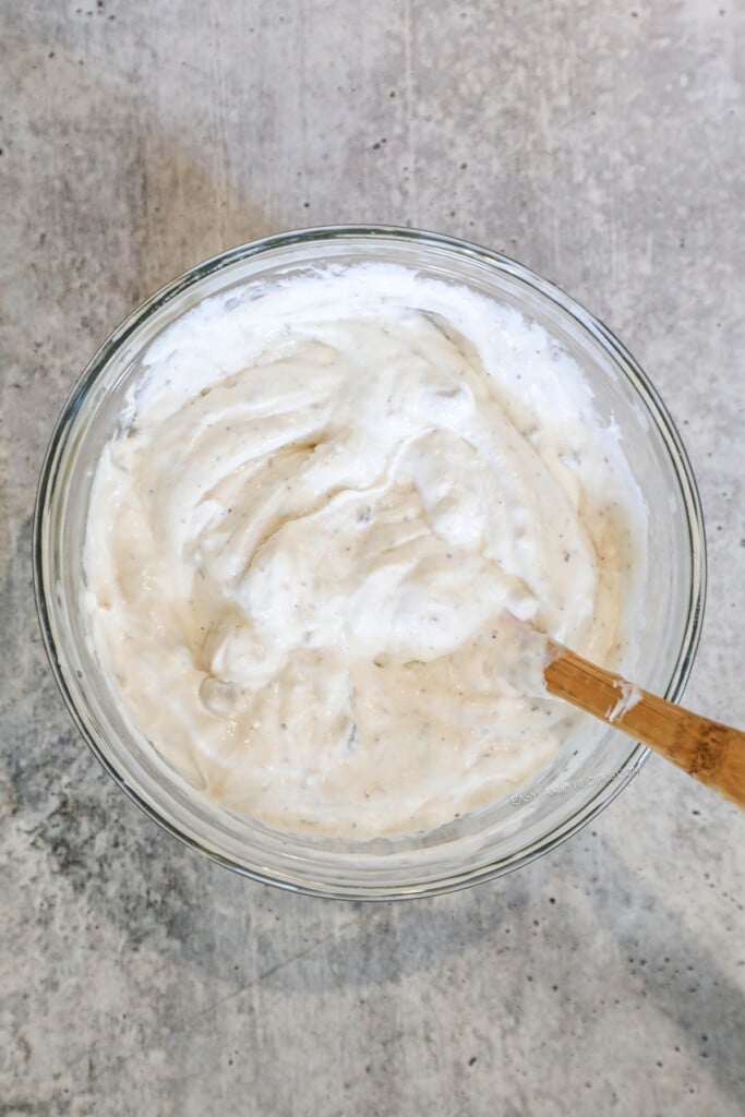 How to make cream of mushroom pork chops step 1: Combine mushroom soup, Italian dressing mix, sour cream, and cheese.