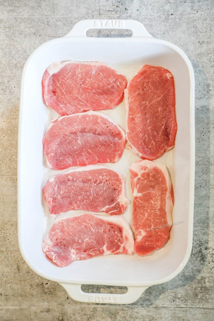 How to make cream of mushroom pork chops step 2: Lay thin cut pork chops in the bottom of a large casserole dish.