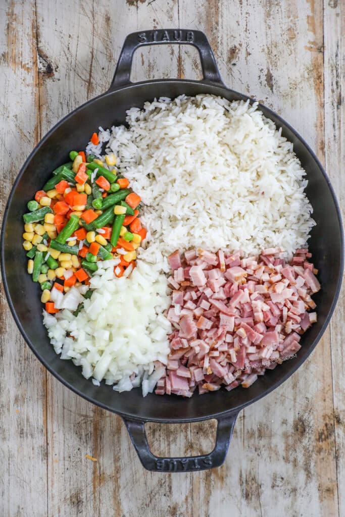 How to make easy ham fried rice step 1: Add the rice, ham and mixed vegetables to the skillet with butter.