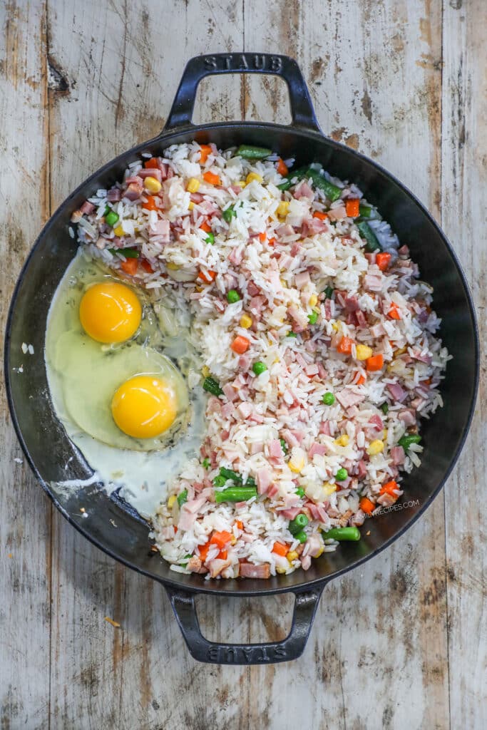 How to make easy ham fried rice step 2: push the rice mixture to the side and scramble the eggs on the other side of the pan.
