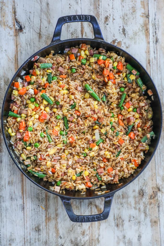 How to make easy ham fried rice step 3: Add soy sauce and mix everything together cooking until it is nice and steamy.