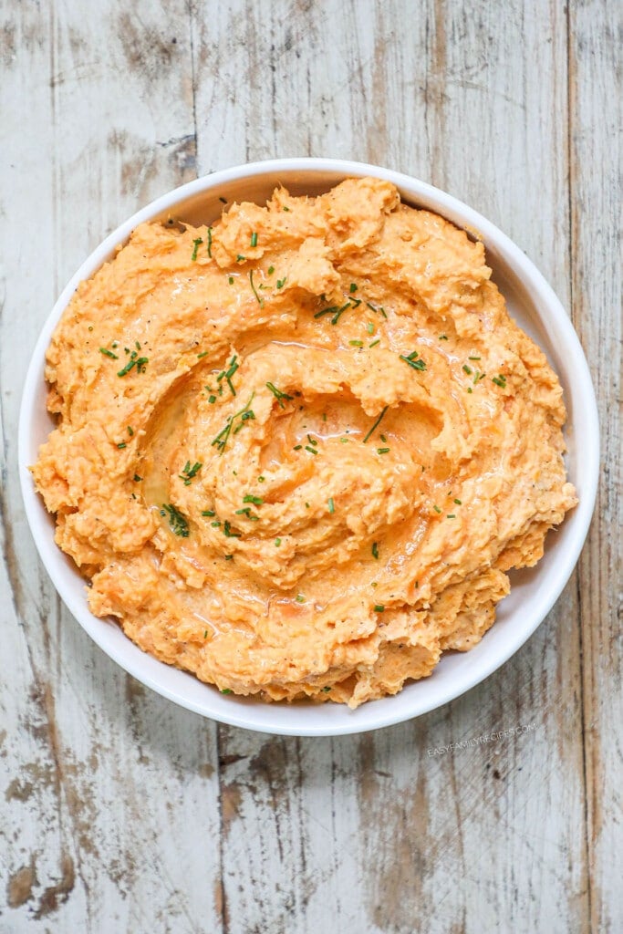 How to make savory mashed sweet potatoes step 3: Mash the potatoes with a potato masher until just blended then top with chives.