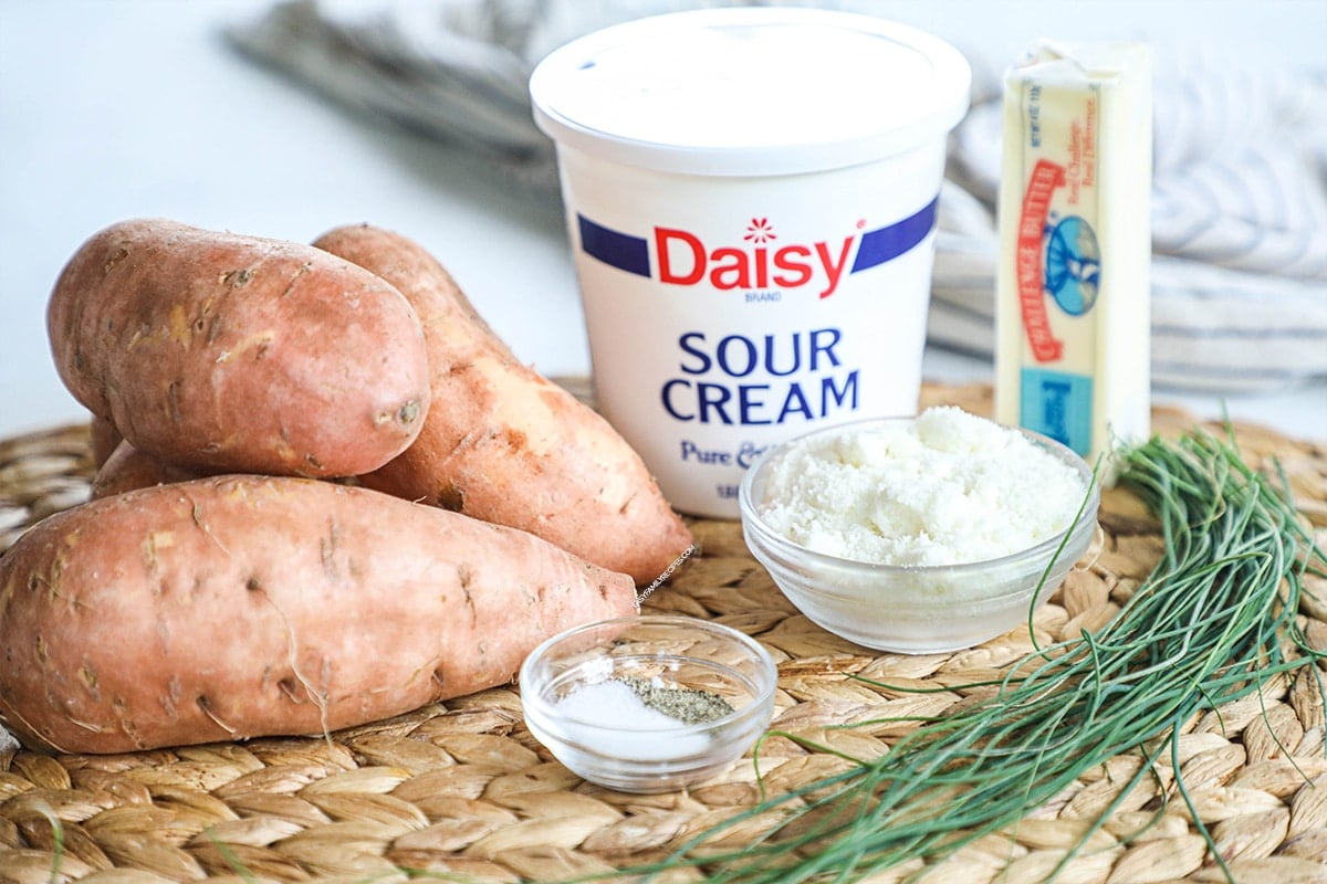 Ingredients to make savory mashed sweet potatoes including sweet potatoes, sour cream, butter, salt, and pepper.