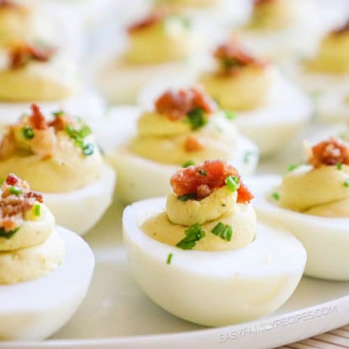 Close up of million dollar deviled eggs, topped with bacon and chives