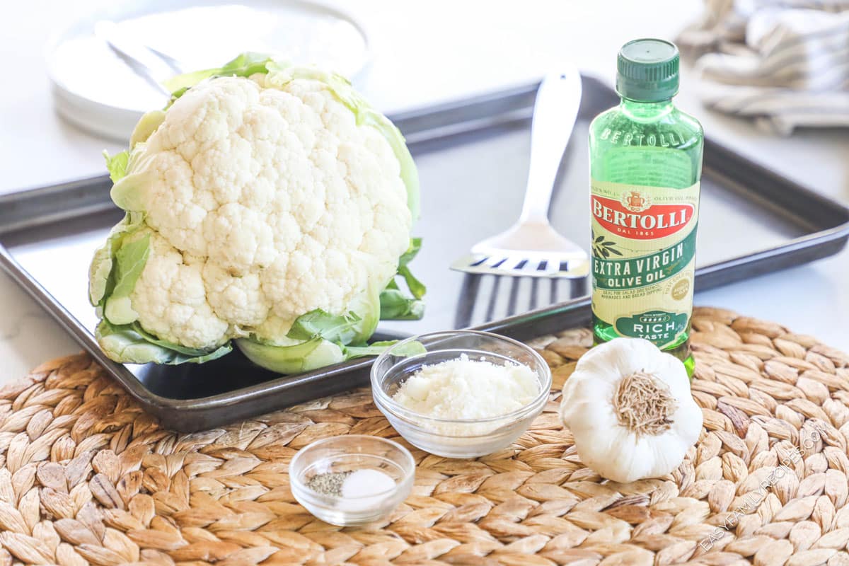 Ingredients for roasted cauliflower including cauliflower, olive oil, parmesan, garlic, salt, and pepper.