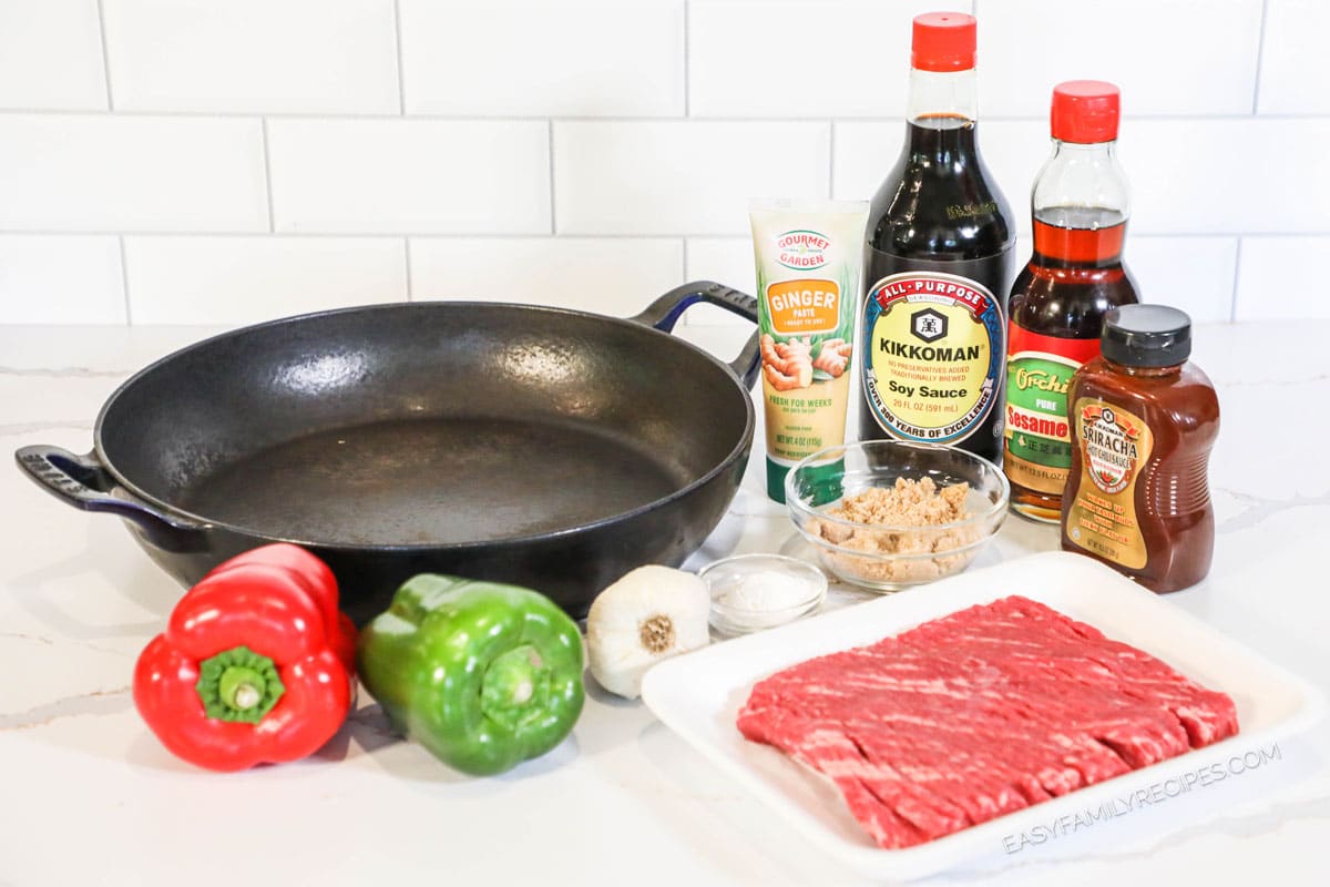 Ingredients to make steak and bell pepper stir fry including garlic, ginger, soy sauce, sesame oil, and brown sugar.