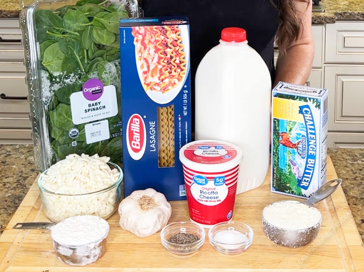 Ingredients for making Spinach Lasagna with White Sauce including lasagna noodles, milk, spinach, garlic, ricotta cheese, and more