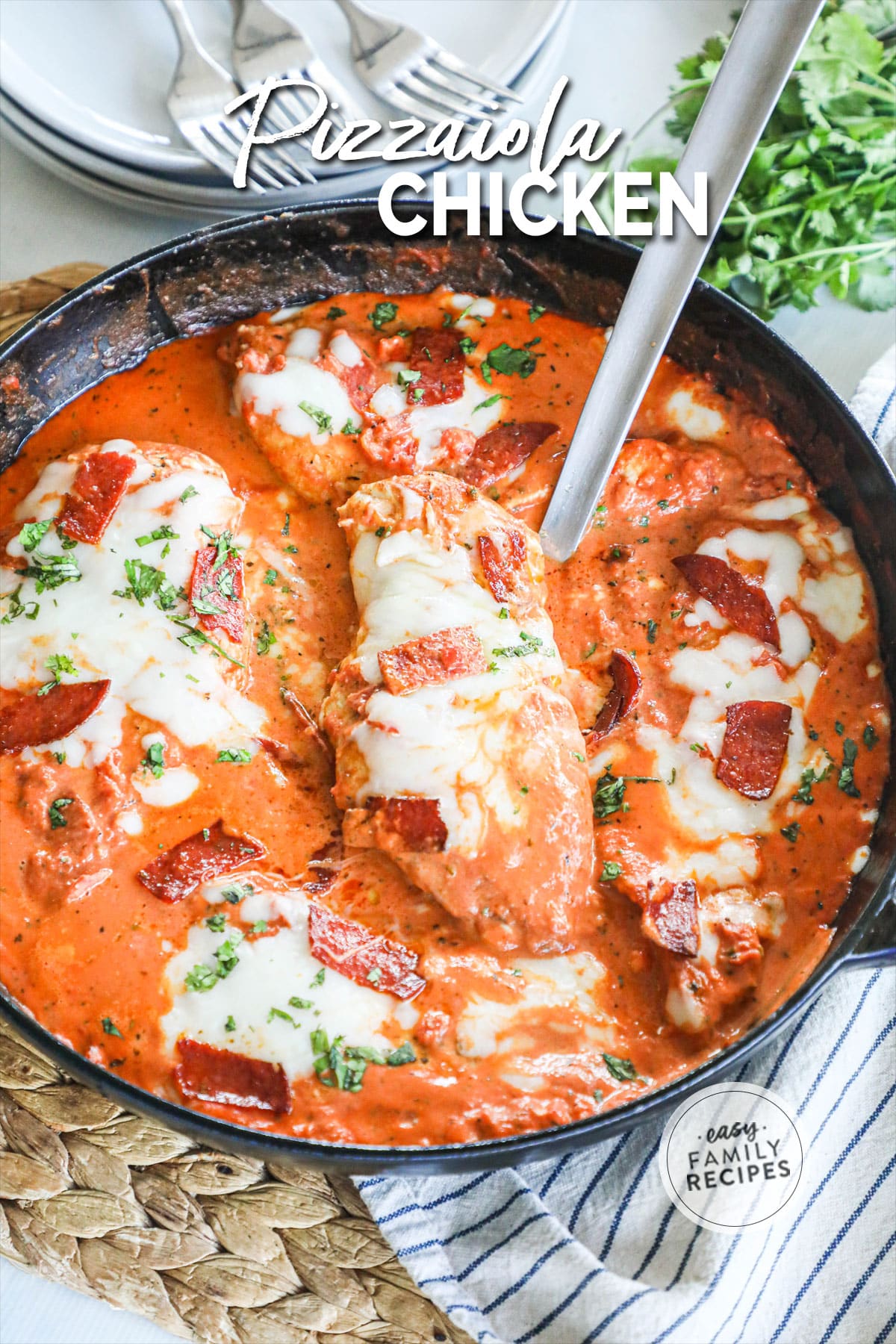 Overhead view of Chicken Pizzaiola in skillet with serving spoon lifting piece of chicken