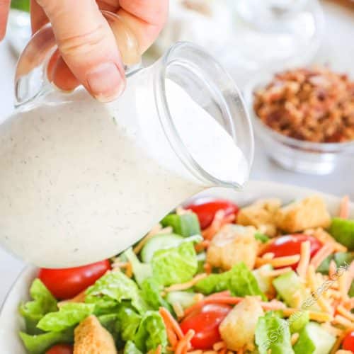 Homemade Buttermilk Dressing being poured over salad