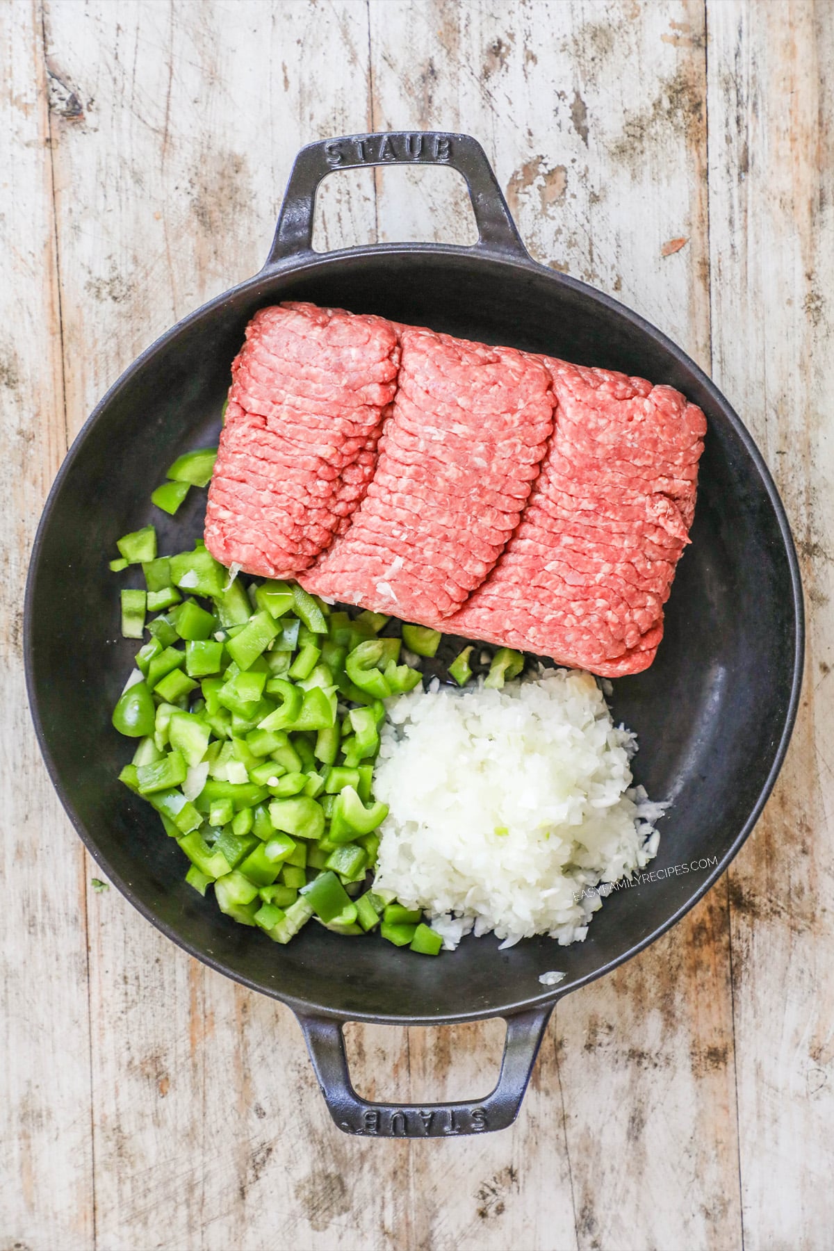 How to make philly cheesesteak sliders - step 1 - add beef, peppers and onions to pan. Cook until done