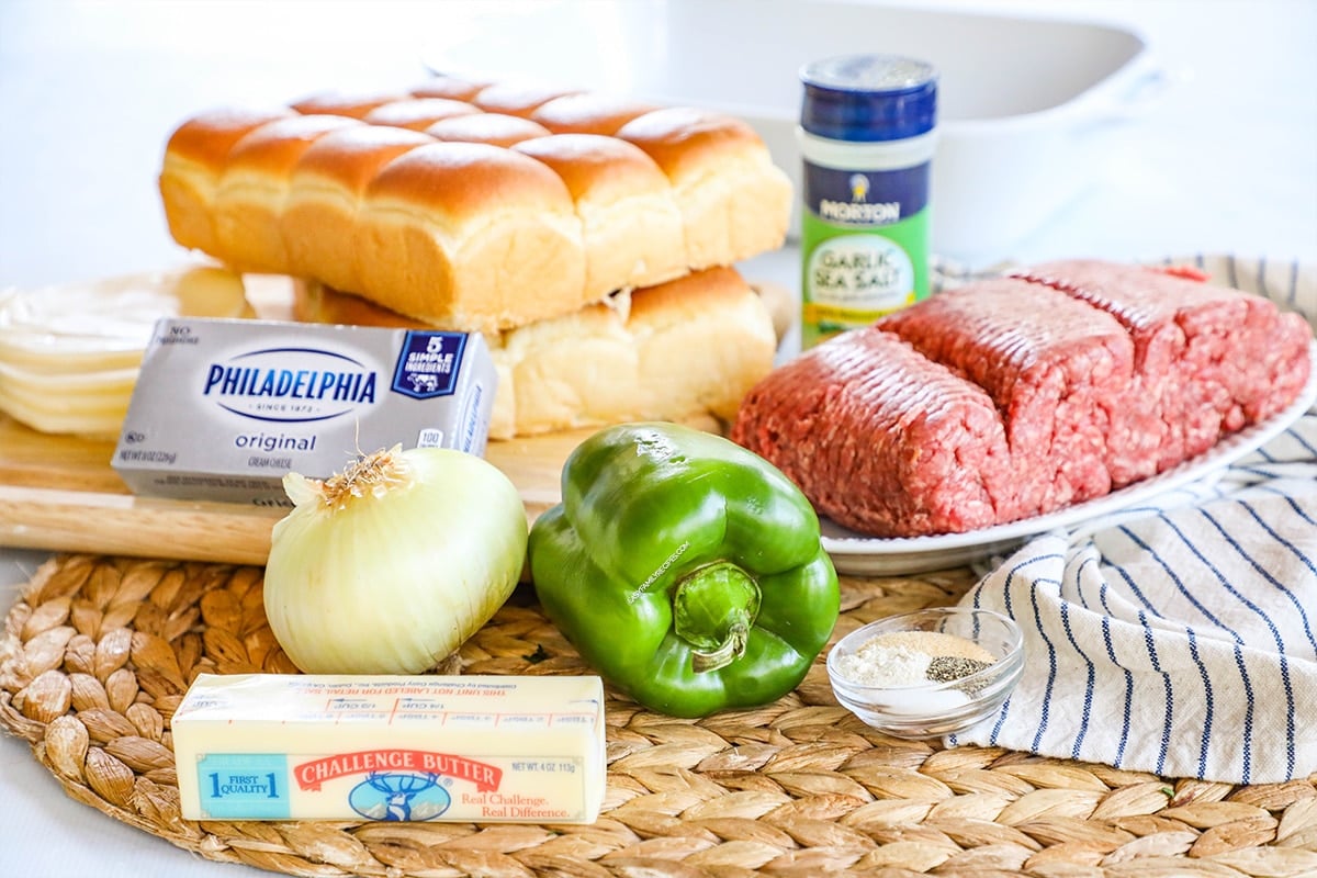 Ingredients for philly cheesesteak casserole including ground beef, cream cheese, bell pepper, onion, provolone cheese and spices