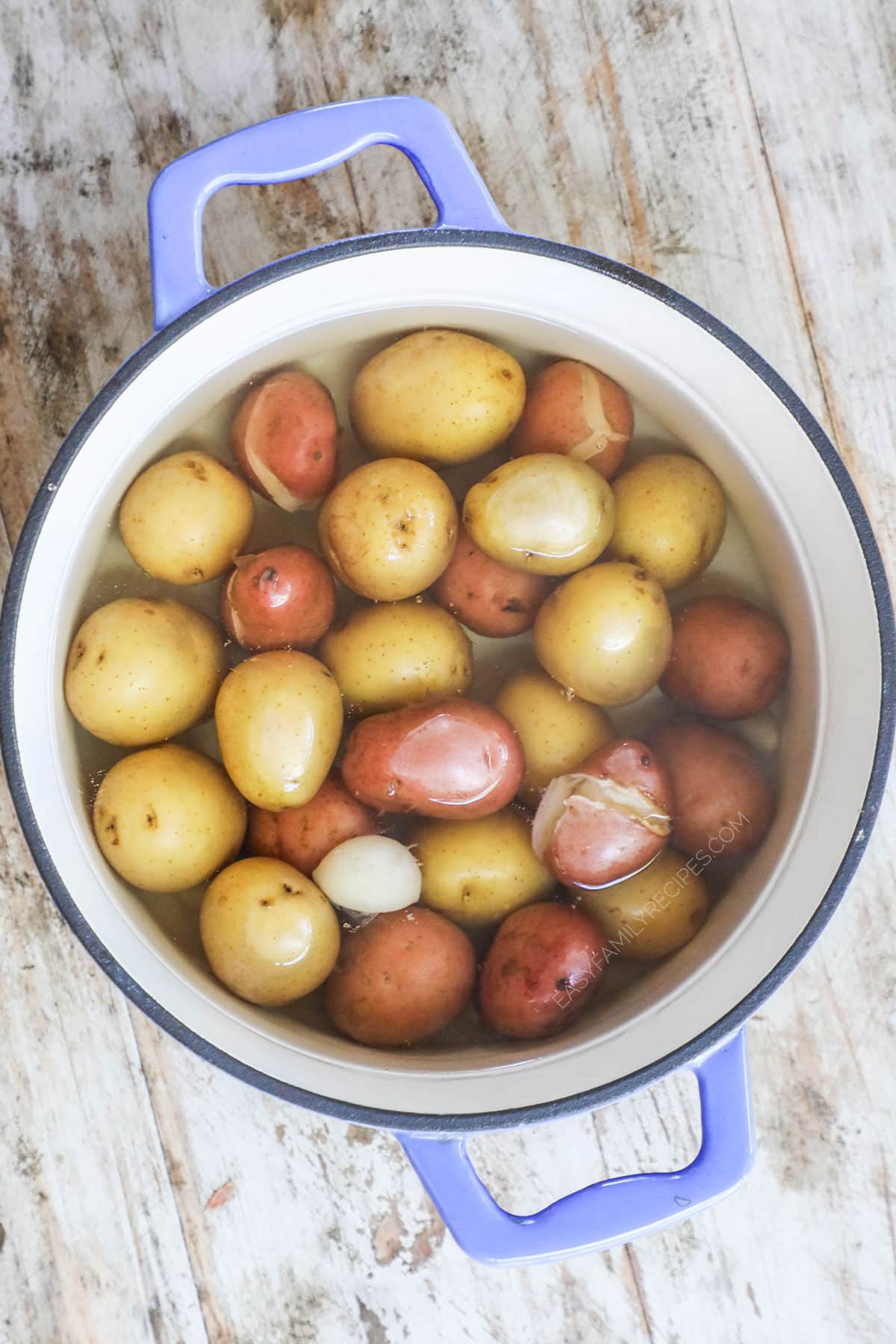 Place potatoes and garlic cloves in a large pot. Cook until potatoes are fork tender